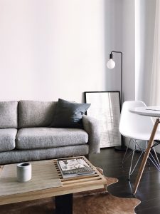 modern livingroom with grey-ish white wall, grey couch, coffeetable